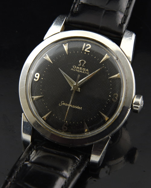 1954 Omega Seamaster stainless steel watch with original black dial, Dauphine hands, raised Arabic markers, and bumper automatic movement.