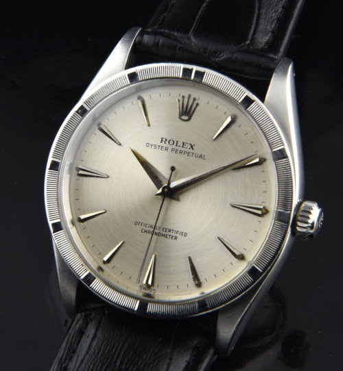1958 Rolex Oyster Perpetual stainless steel watch with original engine-turned bezel, restored dial, Dauphine hands, and automatic movement.