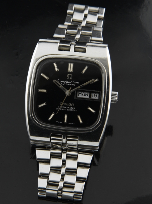 1970s Omega Constellation stainless steel watch with original restored black dial, crystal, winding crown, and automatic winding movement.