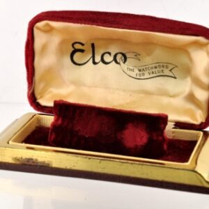 Elco watch box measuring 2.5x5" with burgundy velvet, brass stepped deco sides, and silk interior print.