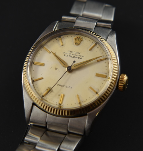 1961 Rolex Explorer steel and 14k gold watch with original bezel, winding crown, Oyster bracelet, and caliber 1530 rotor automatic movement.