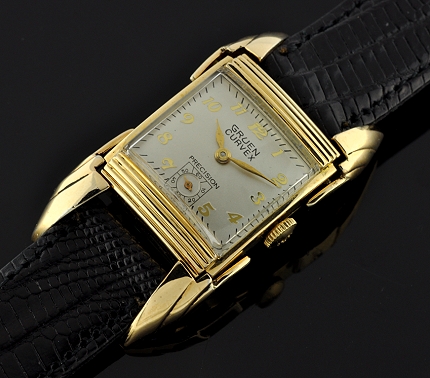 1940s Gruen Curvex "Bat Wing" gold-filled driver's watch with original flexible lugs, silver dial, Arabic numerals, and manual movement.
