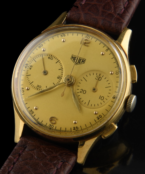 1950s Heuer 18k solid-yellow-gold chronograph watch with original restored dial, feuille-style hands, case, and manual winding movement.
