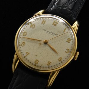 1950s IWC solid 18k yellow gold watch with original elongated lugs, dial, raised Arabic numerals, and manual winding caliber 89 movement.