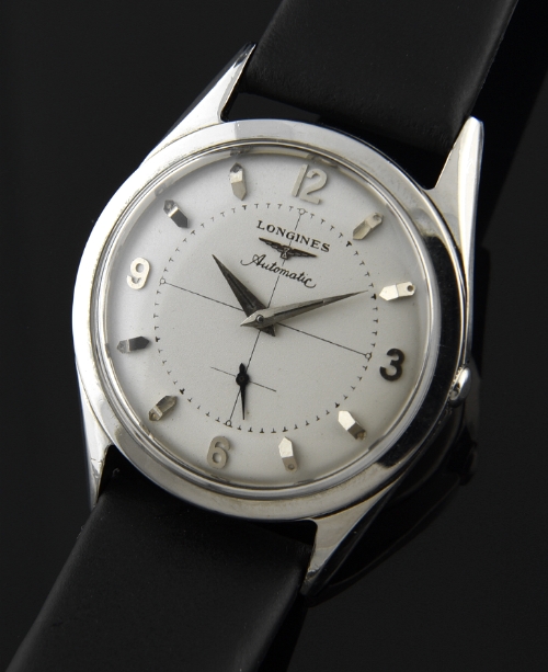 1956 Longines stainless steel watch with original restored dial, raised Arabic numerals, markers, sword hands, and rotor automatic movement.