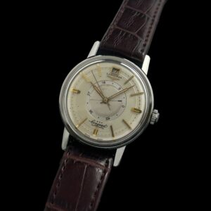 1950s Longines Conquest stainless steel watch with original power-reserve feature, signed winding crown, case, and well-preserved emblem.