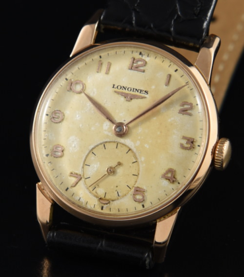 1952 Longines 28.5mm 18k solid-rose-gold watch with original dog's leg lugs, Arabic numerals, dial, and cleaned manual winding movement.