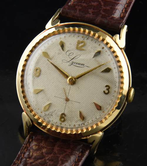 1950s Lyceum 14k solid-gold watch with original ridged bezel, stylized lugs, waffle dial, dagger hands, and manual winding Swiss movement.