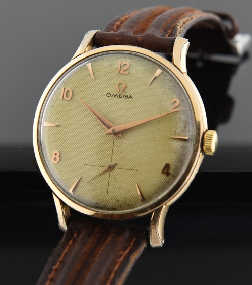 1954 Omega gold-plated steel-back watch with original waffle dial, rose-toned markers, hands, and caliber 266 manual winding movement.