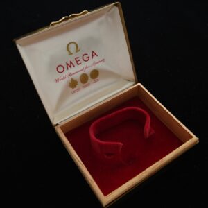 Omega gold metal 1960s box measuring 3.75x4.5" with silk and red velvet insert for men's vintage Omega.