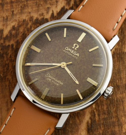 1960s Omega 34mm Seamster De Ville stainless steel watch with original case, dial, gold-toned markers, and automatic 500 series movement.