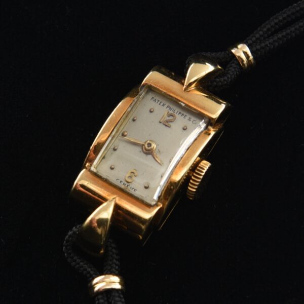 1950s Patek Philippe 18k gold ladies cocktail watch with original dial, case, new band with gold-filled clasp, and manual winding movement.