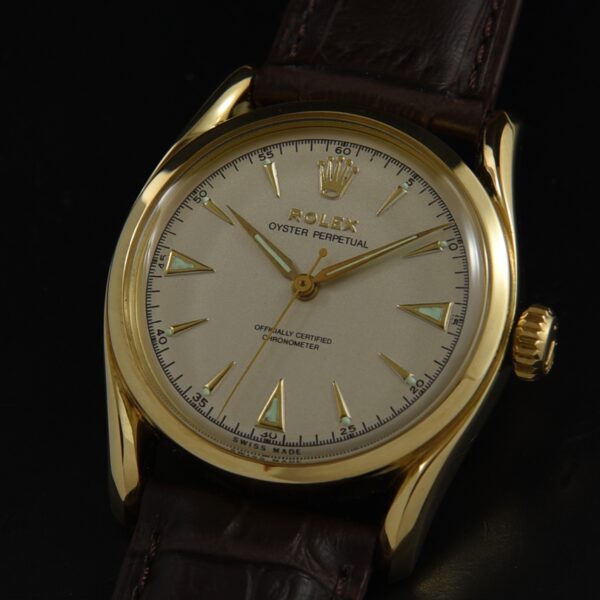 1952 Rolex 33mm Bombay solid-gold watch with restored dial, original triangular markers, and large Bubbleback automatic winding movement.