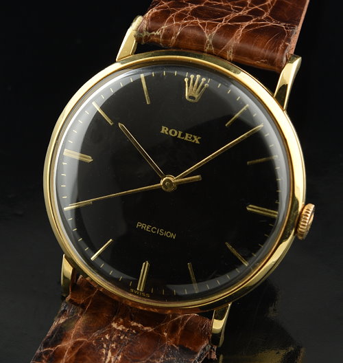 1955 Rolex Precision 18k solid-gold watch with original black dial, hands, case, winding crown, and clean, accurate manual winding movement.