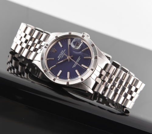 1984 Rolex Oyster Perpetual Date stainless steel watch with original blue dial, papers, Jubilee bracelet, engine-turned bezel, and case.