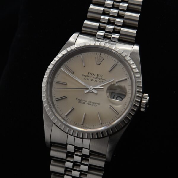 1989 Rolex Datejust stainless steel watch with original Jubilee bracelet, silver dial, golden patina, and caliber 3135 automatic movement.