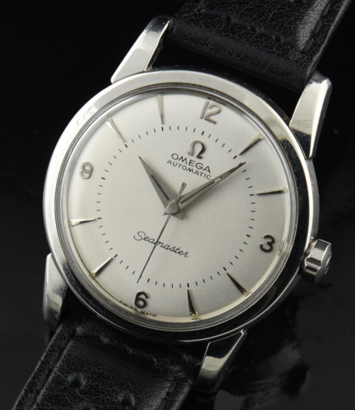 1956 Omega Seamaster stainless steel watch with original dial, Arabic numerals, winding crown, and caliber 500 automatic winding movement.