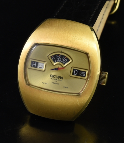 1970s Sicura stainless steel direct-read digital watch with original three apertures displaying hours, minutes, date, and rotating seconds.