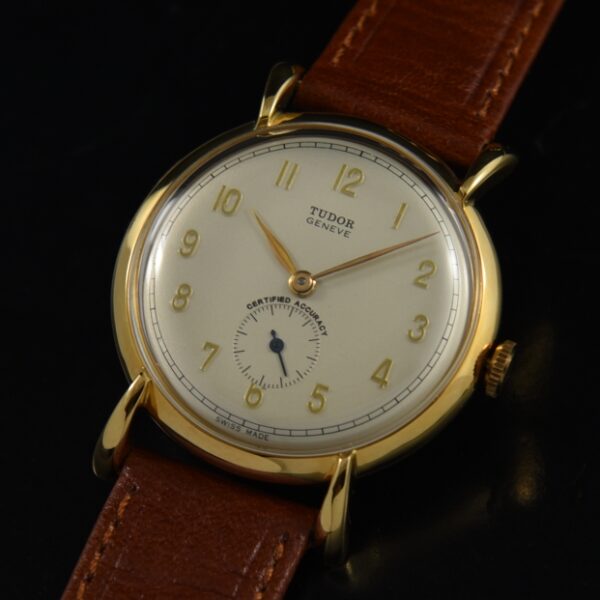 1950s rare Tudor gold-plated stainless steel watch with flared lugs, original case, manual winding movement, and raised Arabic numerals.