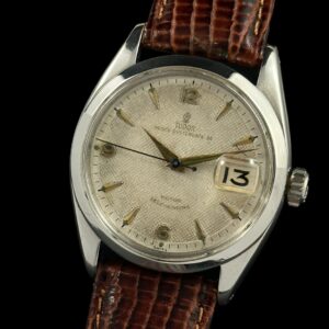 1950s Tudor Oyster Prince 34 stainless steel watch with original honeycomb dial, numerals, Dauphine hands, and cleaned caliber 390 movement.