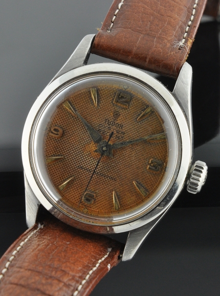 1950s Tudor Oyster Regent stainless steel watch with original case, honeycomb dial, Dauphine hands, and clean Rolex manual winding movement.
