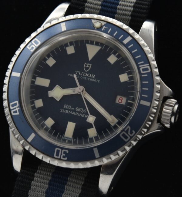 1968 Tudor Submariner 40mm stainless steel 'Snowflake' watch with original dial, hands, blue bezel, red date, and automatic Tudor movement.