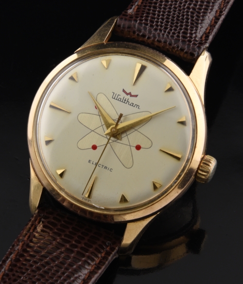 1960s Waltham Electric gold-plated watch with original case, cross-hatched setting crown, unusual atomic-logo dial, and serviced movement.