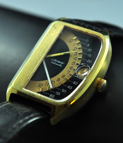 1975 Wittnauer Futurama Sector 1000 gold-plated watch with original case, black and gold dial, bubble-date crystal, and automatic movement.
