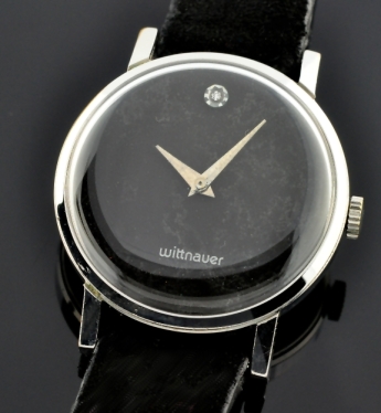 1970s Wittnauer chrome-plated dress watch with original black dial, diamond 12:00 marker, scratchless case, and manual winding movement.