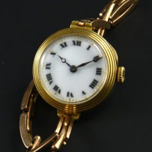 1920s 18k solid-gold ladies cocktail watch with original stepped bezel, Roman numeral porcelain dial, bracelet, and manual winding movement.