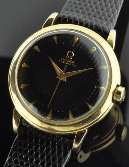 1951 Omega gold-filled watch with original glossy black honeycomb dial, Dauphine hands, case, and cleaned bumper automatic winding movement.