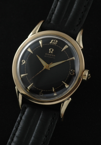 1950 Omega gold-capped watch with original horn lugs, case, winding crown, restored black dial, and caliber 351 bumper automatic movement.