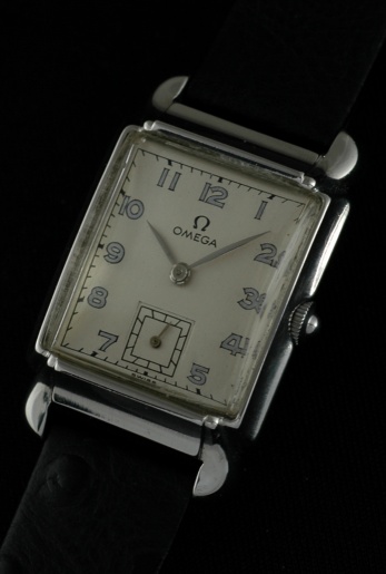 1944 Omega stainless steel watch with original rectangular case, flared lugs, restored dial, Arabic numerals, and manual winding movement.