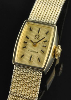 1973 Omega gold-filled ladies watch with original logo buckle, integrated mesh bracelet, ribbed dial, spotless case, and winding crown.