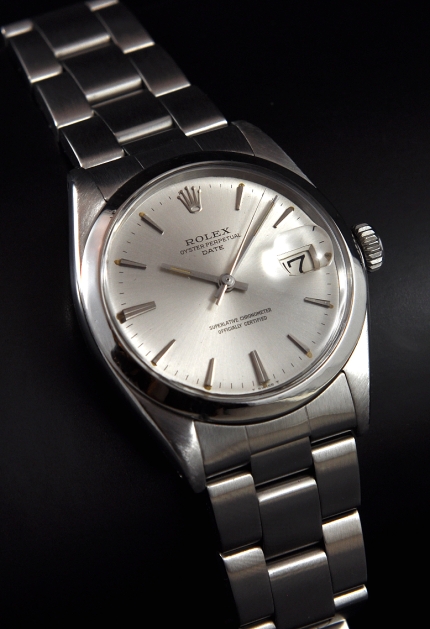 1967 Rolex Oyster Perpetual Date stainless steel watch with original case, dial, elongated baton markers, hands, and automatic movement.