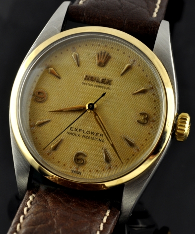 1954 Rolex Oyster Perpetual Explorer stainless steel watch with original gold bezel, dagger hands, honeycomb dial, and automatic movement.