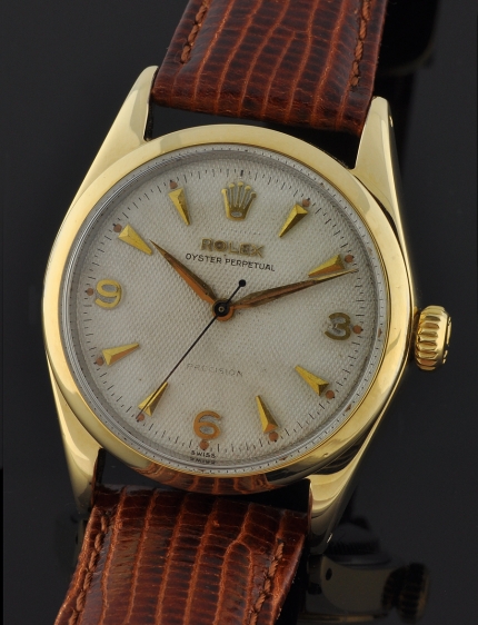 1952 Rolex Oyster Perpetual Date gold-plated watch with original case, cross-style winding crown, honeycomb dial, and automatic movement.