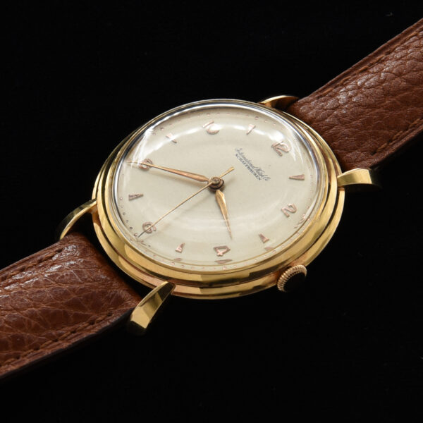 This is a prime example of an original vintage IWC in solid 18k gold measuring a large 37mm. The original dial is highlighted with rose toned Arabic and arrow markers and Lance style hands.