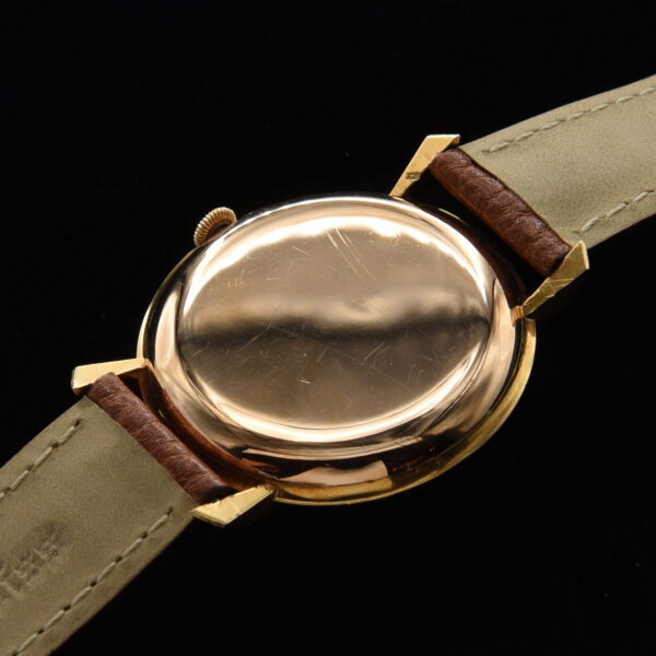 This is a prime example of an original vintage IWC in solid 18k gold measuring a large 37mm. The original dial is highlighted with rose toned Arabic and arrow markers and Lance style hands.