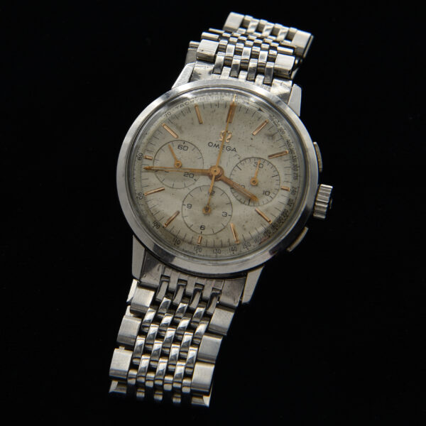 This is an incredibly rare Omega 321 caliber manual winding chronograph from 1965, measuring 35mm. This vintage Omega watch features an original dial and hands, showcasing the expected aging and patina for an authentic vintage appearance. The legendary manual winding caliber 321 movement, famously worn to the moon in the Speedmaster, has been meticulously serviced and operates flawlessly. Encased in a large 35mm stainless steel case with flat pushers, this watch comes with a flat-link Omega vintage bracelet and the Omega winding crown. It is important to note that this ref. 101.010 model is exceedingly scarce.