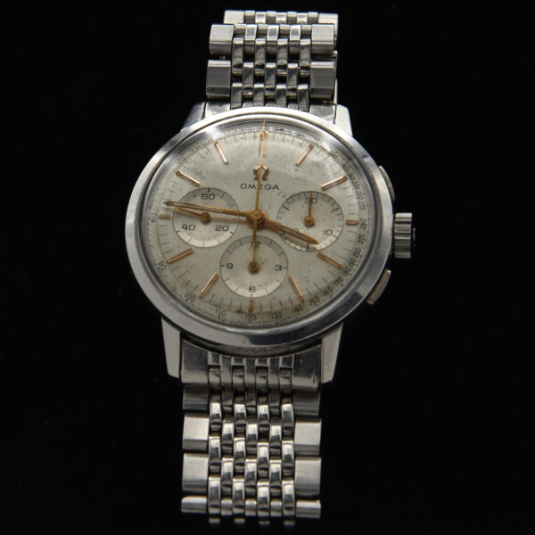 This is an incredibly rare Omega 321 caliber manual winding chronograph from 1965, measuring 35mm. This vintage Omega watch features an original dial and hands, showcasing the expected aging and patina for an authentic vintage appearance. The legendary manual winding caliber 321 movement, famously worn to the moon in the Speedmaster, has been meticulously serviced and operates flawlessly. Encased in a large 35mm stainless steel case with flat pushers, this watch comes with a flat-link Omega vintage bracelet and the Omega winding crown. It is important to note that this ref. 101.010 model is exceedingly scarce.