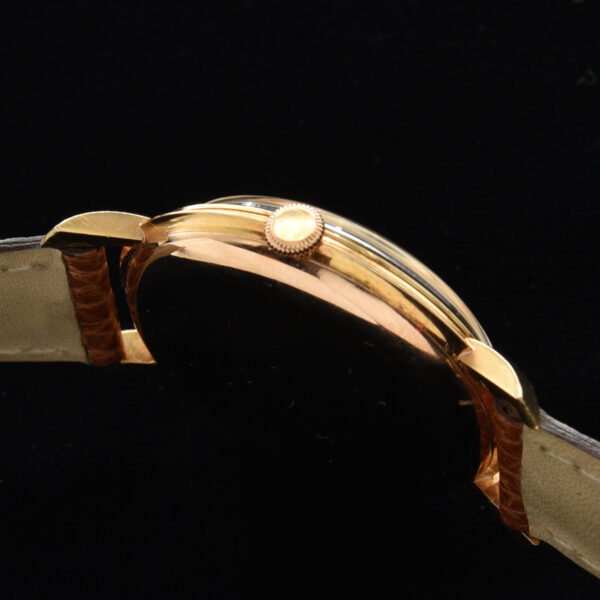 This is a prime example of an original vintage IWC in solid 18k gold measuring a large 37mm. The original dial is highlighted with rose toned Arabic and arrow markers and Lance style hands.