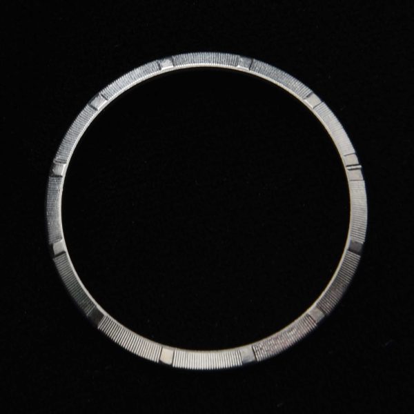 This stainless steel engine-turned bezel fits the ref. 1002-1003 34mm Rolex Oyster watch. This bezel looks pristine when viewed in person.