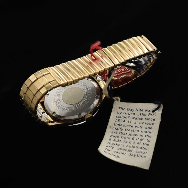 This is an uncommon and NOS (unused) vintage early '70s Gruen watch known as the Day/Night measuring 33mm in a pristine gold-plated case with hang-tags and sticker as it was sold new.