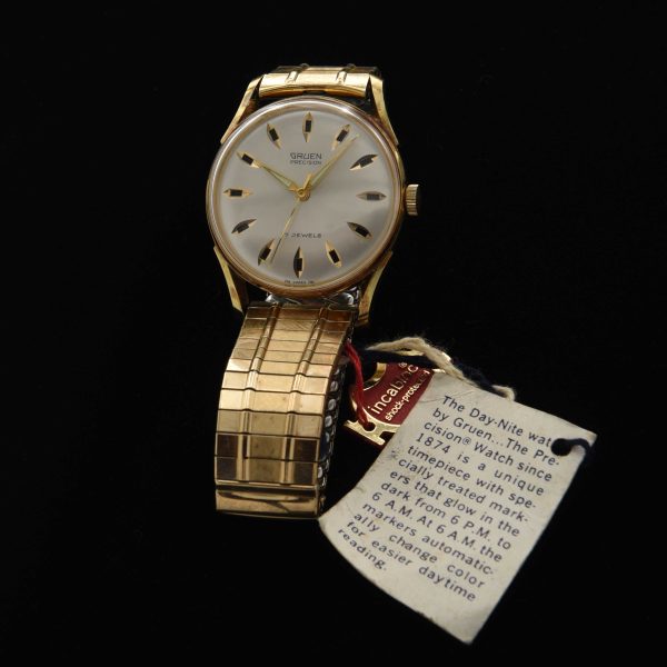This is an uncommon and NOS (unused) vintage early '70s Gruen watch known as the Day/Night measuring 33mm in a pristine gold-plated case with hang-tags and sticker as it was sold new.